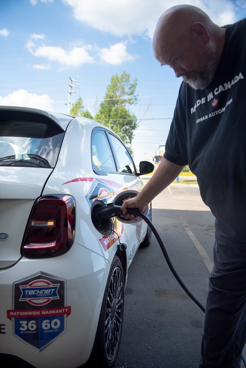 Charging the Urban Automotive 2025 Fiat 500e electric shuttle in Oakville