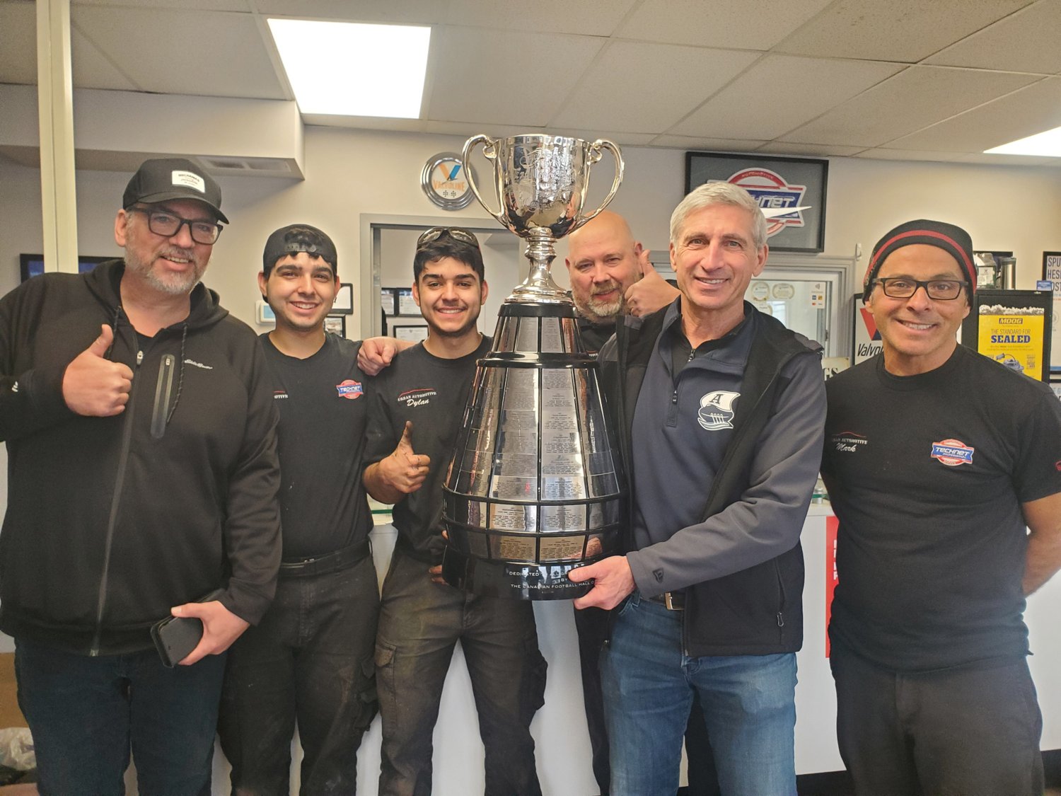 The Urban Automotive team with the Grey Cup at their Oakville shop